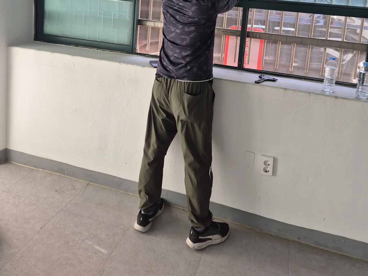 사무실 창가에서 창틀 쪽을 닦는 작업자 뒷모습